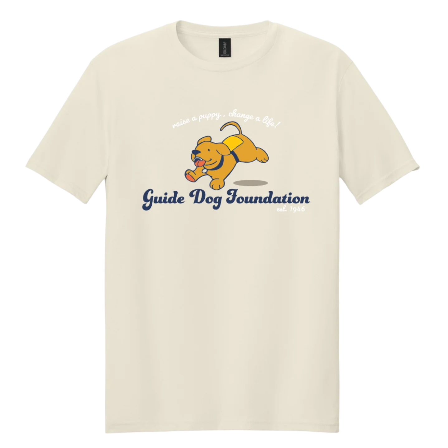 A natural-colored unisex T-shirt featuring a cartoon-style yellow Labrador puppy wearing a yellow guide dog training vest. The puppy is mid-run, joyfully carrying a bone in its mouth. Above the illustration is white script text that reads “raise a puppy, change a life!” Below the image, the Guide Dog Foundation logo appears in a bold navy script, with “est. 1946” in smaller white text beside it.