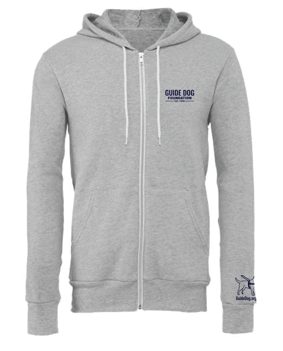 Image description: A soft, grey zip-up sweatshirt with a white zipper running down the front. The sweatshirt has white drawstrings for the hood and features the navy Guide Dog Foundation logo embroidered on the left chest. Additionally, the Guide Dog Foundation logo, depicting a guide dog, is present on the left sleeve, accompanied by the "GuideDog.org" URL written underneath in a clear, legible font.